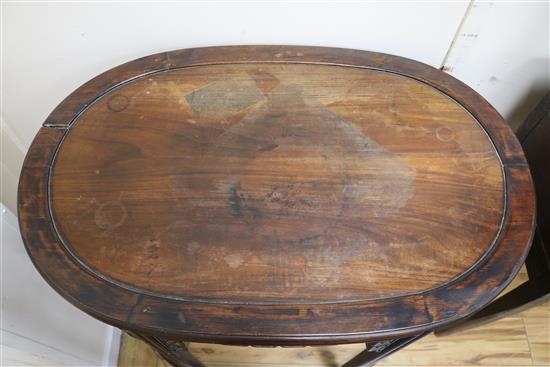 A Chinese carved hardwood oval pedestal table with pierced frieze and peripheral stretcher W.87cm